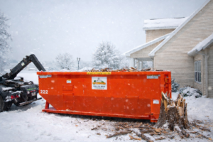 An orange roll-off dumpster from City Disposal Services Inc. filled with debris next to a house in Appleton, WI.