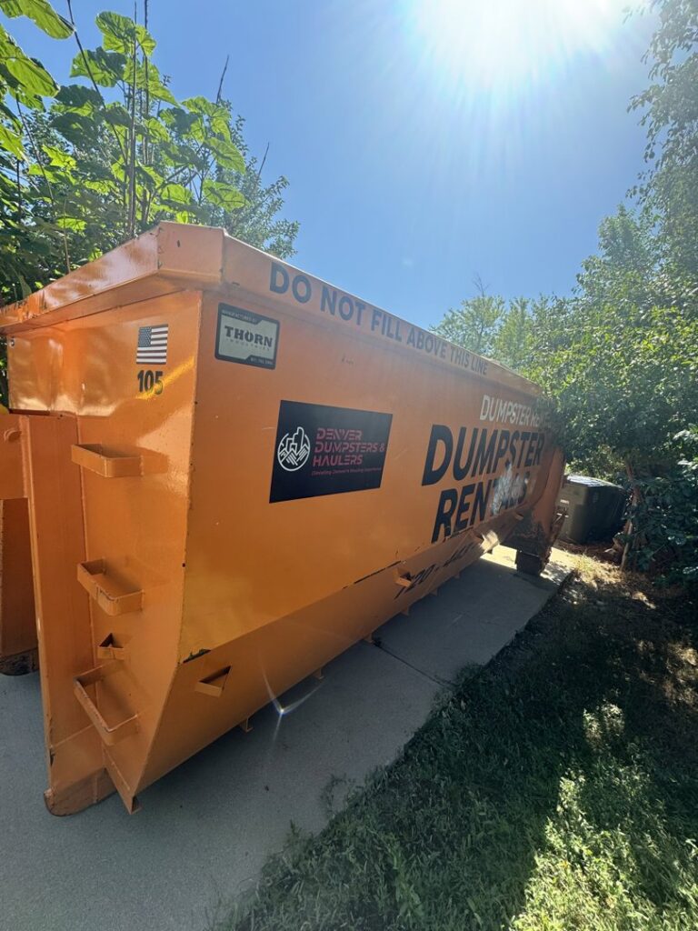 An orange roll-off dumpster with Denver Dumpsters logo, available for rent in Denver, CO.