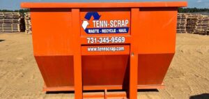 A branded orange roll-off dumpster from Tenn-Scrap, available for junk removal in Jackson, TN.