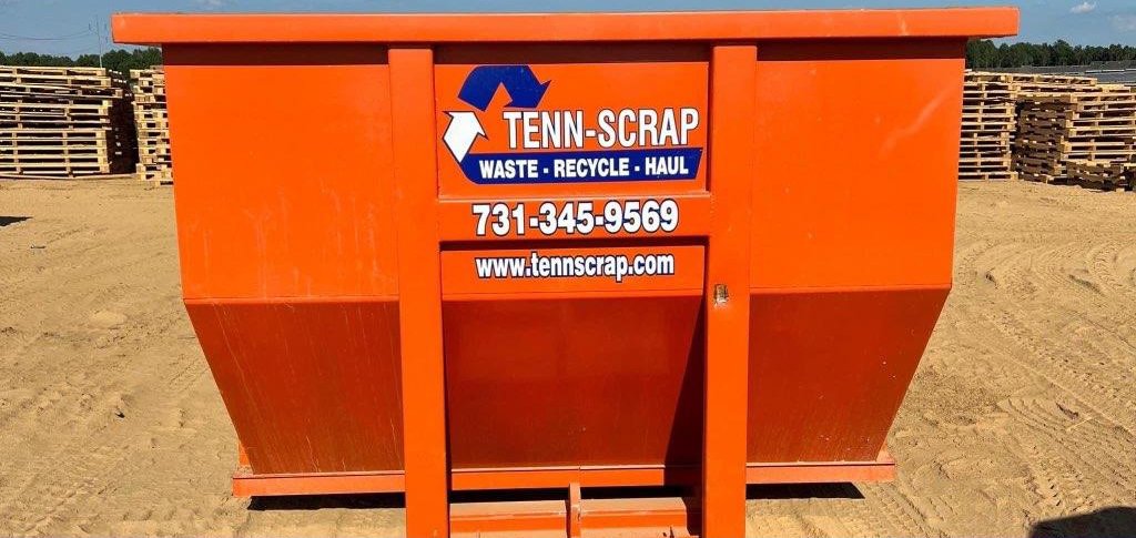 A branded orange roll-off dumpster from Tenn-Scrap, available for junk removal in Jackson, TN.