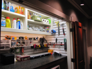An organized utility closet with custom shelving and pegboard for tools and supplies by Jackson Construction in Oak Hills Place, LA
