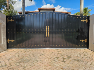 A large, ornate black double gate with gold hardware installed by Aluminum Fence Contractor, Inc. in Hialeah, FL.