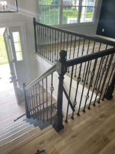 An interior staircase featuring ornate black iron railings and newel posts by AC Fence and Ironworks in Philadelphia, PA.