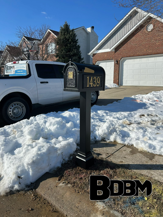 An ornate black mailbox with gold accents and house number 1439 installed by Big Dicks Brick Mailboxes in St. Louis, MO.