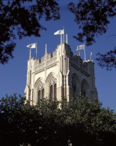 An ornate stone tower adorned with flags, showcasing detailed craftsmanship by Dallas Cast Stone in Dallas, TX