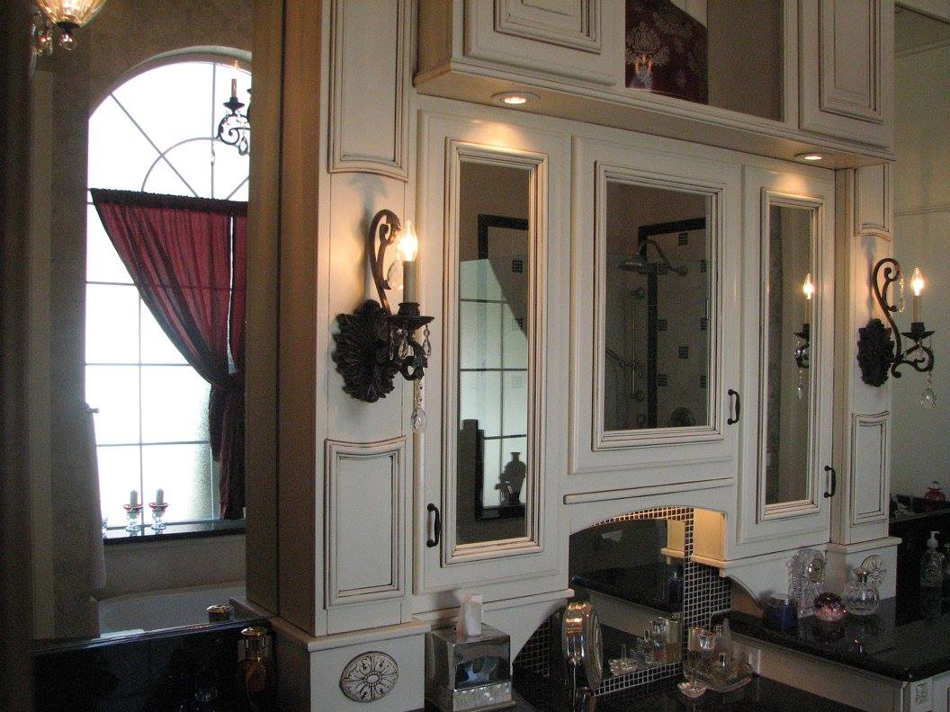 Ornate white bathroom cabinets with elegant sconces installed by Metro Contractors & Supply, Inc. in Norman, OK