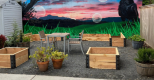 An outdoor area featuring custom empty raised garden beds and a colorful mural by PNW Home Improvements, LLC in Portland, OR