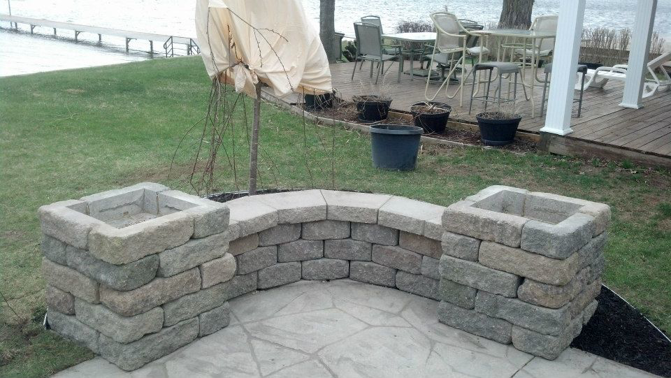 An outdoor seating area with curved block benches and planters built by Cutler Builders in Caledonia, MI.