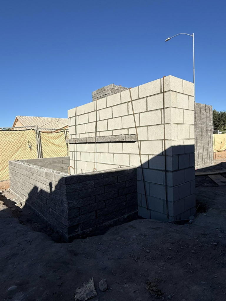 An outdoor block structure under construction, showcasing masonry work by Milflores King Construction LLC in Glendale, AZ