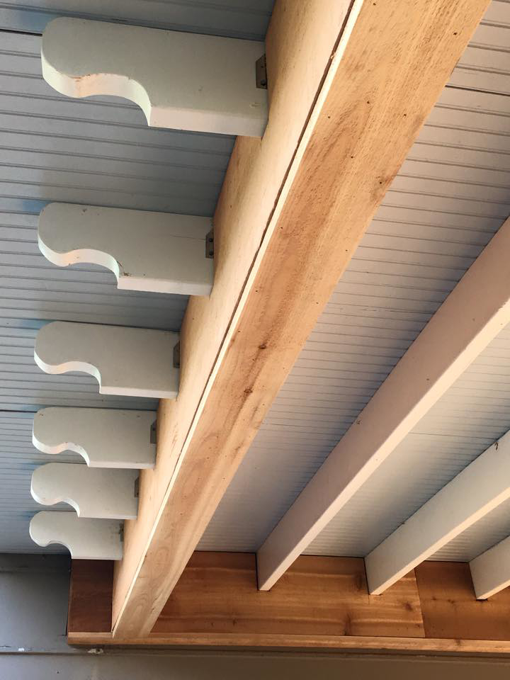Detailed view of outdoor ceiling construction with decorative white brackets by Felipe Garcia Remodeling and Construction in Mobile, AL.
