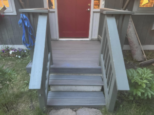 Outdoor composite deck and stairs leading to a front door by Blue Heron Property Care LLC in Kalispell, MT