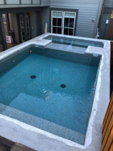 An outdoor concrete pool and spa under construction, showcasing general contractor work by Kaleidoscope Design Build in Houston, TX.