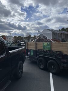 A large pile of construction debris, wood, and household junk accumulated outside a residential building, ready for removal by Trash King LLC in Peoria, AZ.