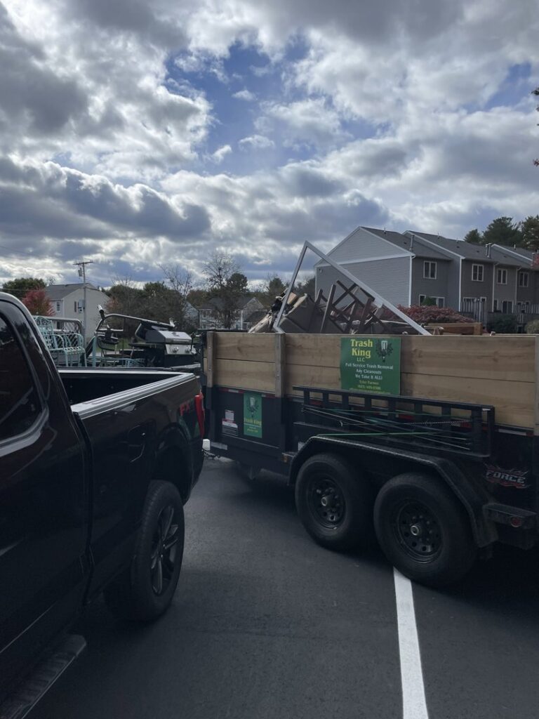 A large pile of construction debris, wood, and household junk accumulated outside a residential building, ready for removal by Trash King LLC in Peoria, AZ.