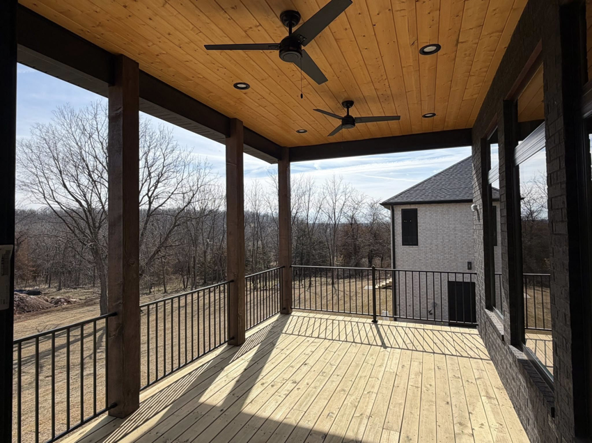 A newly constructed outdoor covered deck with ceiling fans by ELS Construction in Springfield, MO.