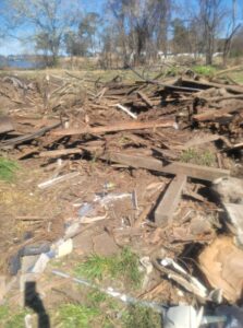 Outdoor area with wood debris, branches, and trash, cleared by P and P Junk Removal and Demolition Services in Norfolk, VA.