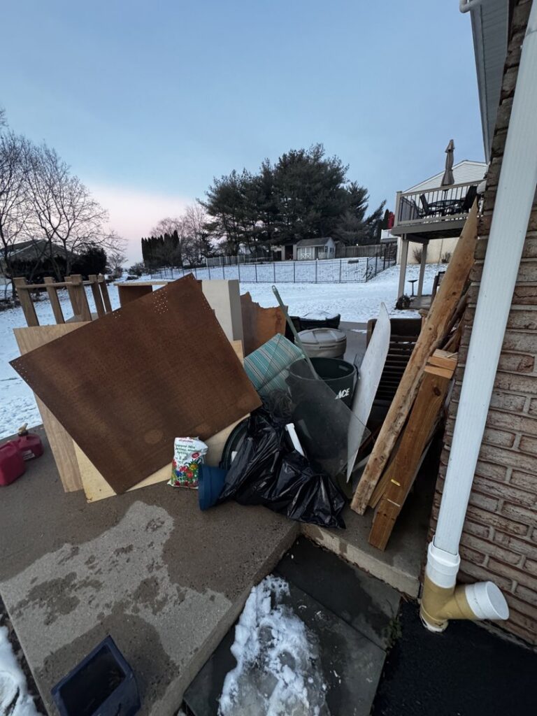 A pile of outdoor debris including wood, cardboard, and trash bags, ready for junk removal by Vatter Hauling Service in Lancaster, PA.