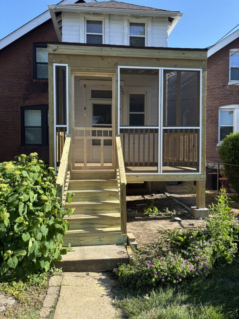 A newly built outdoor wooden deck with a staircase leading to a patio area, completed by McIntosh Construction in Des Peres, MO.