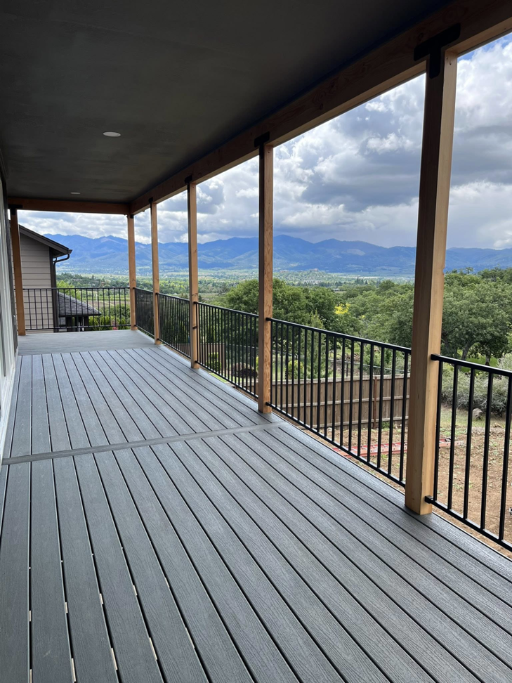Newly constructed outdoor deck with railings by Denn Construction, Inc. in Medford, OR.