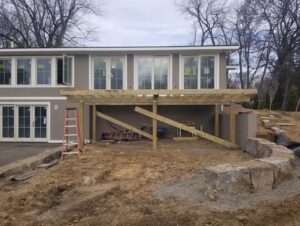 Outdoor wooden deck under construction at a residential property by Rochester Remodeling and Home Builders in Rochester, NY.