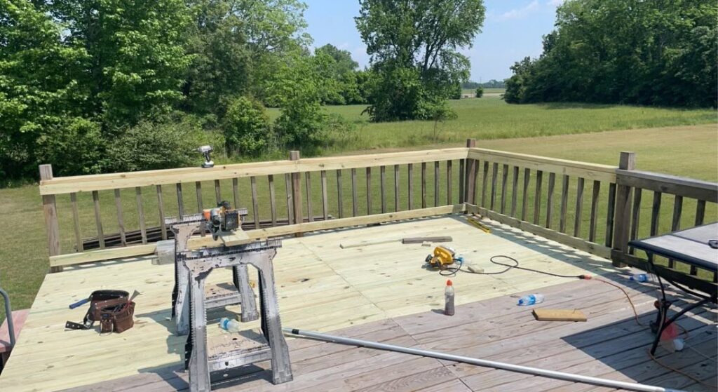 Outdoor deck construction with new wood planks and tools by KG Handyman & Remodeling in Vilonia, AR.