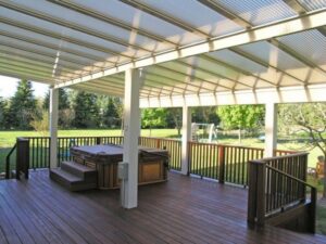 An outdoor deck with a hot tub and a translucent roof structure, built by Pro Renovations Savannah, GA.