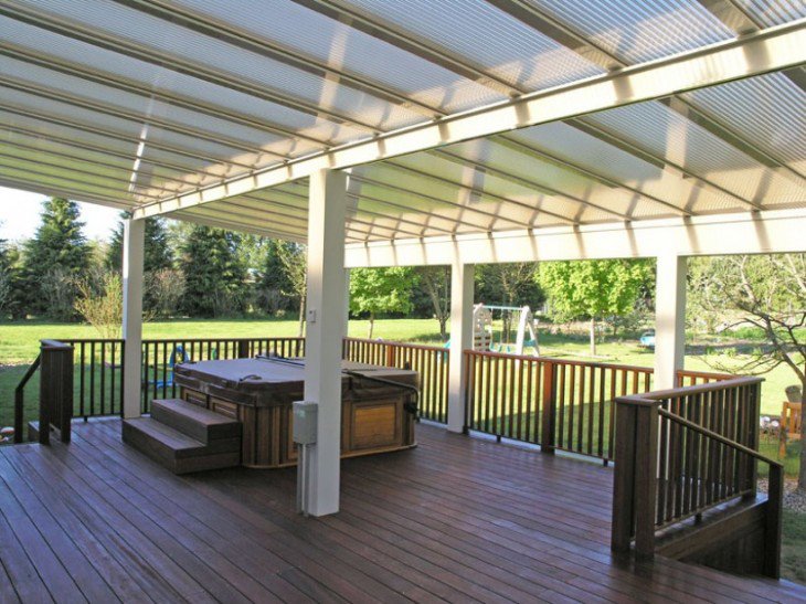An outdoor deck with a hot tub and a translucent roof structure, built by Pro Renovations Savannah, GA.