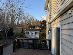 An outdoor deck addition viewed from the side of a house, completed by Harris Home Creations in Philadelphia, PA.