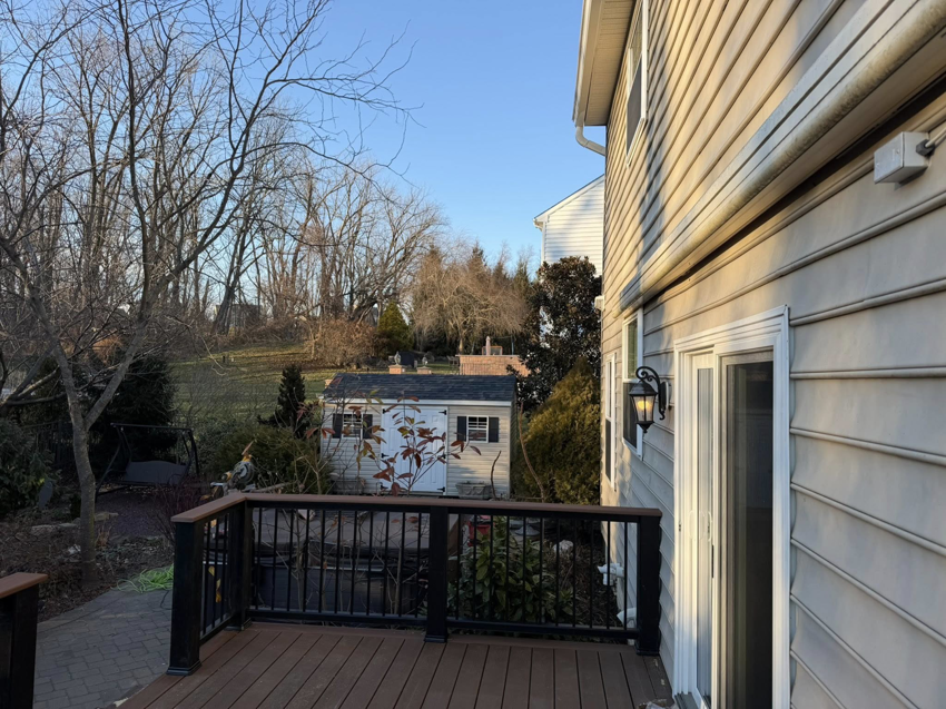 An outdoor deck addition viewed from the side of a house, completed by Harris Home Creations in Philadelphia, PA.