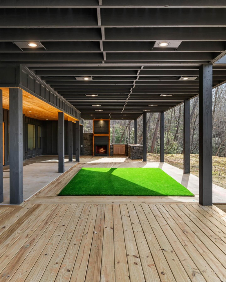 A spacious outdoor deck and covered patio with an outdoor fireplace, built by The Renovation Spot in Smyrna, GA.