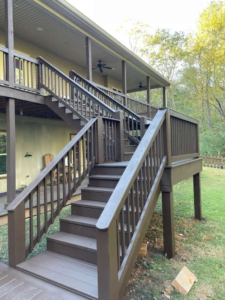 A newly constructed or freshly stained large outdoor wooden deck with stairs, built by Safe Haven Home Services in Nashville, TN.