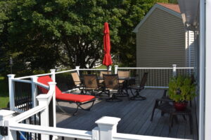 A spacious outdoor wooden deck with patio furniture, showcasing quality work by Casco Bay Construction Services, LLC in South Portland, ME.