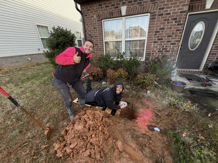 Two handymen working on an outdoor digging project for JM Home and Property Services in Clarksville, TN