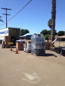 An outdoor electronics collection event with pallets of e-waste and a truck for SES Secure E-Waste Solutions Inc. in San Diego, CA.