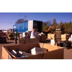 An outdoor e-waste collection and loading operation with a forklift and large boxes, handled by E-Waste Recovery Systems in Sacramento, CA.