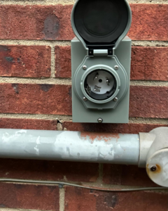 An outdoor electrical outlet installation on a brick wall completed by Gingy's Electrical Services, LLC in Memphis, TN.