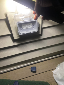 An outdoor electrical outlet with a weather-resistant cover being installed by Handy Hubby South Elgin, IL