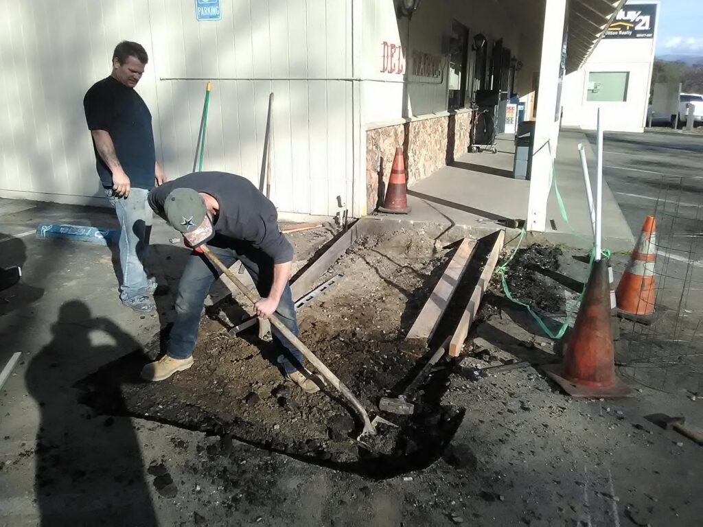 Contractors performing outdoor excavation and concrete preparation for Red Gator Maintenance in Fresno, CA.
