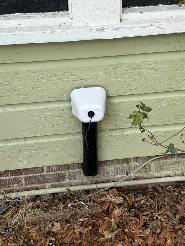 An outdoor faucet with protective insulation installed on a house wall, a service provided by Helms Plumbing and Drains in Charlotte, NC.