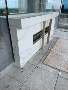 An outdoor fireplace and bar area under construction on a patio by Martina Bros. Inc. in Lexington, KY.