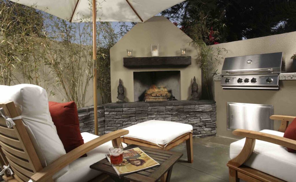 An outdoor living space featuring a stone fireplace and built-in grill by St. Charles Deck in St. Charles, MO