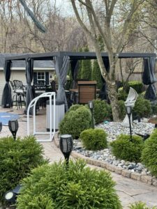 A newly installed outdoor gazebo or pergola with seating and landscaping by Landscape By Today in Bowie, MD.