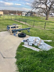 Discarded outdoor gym equipment and other debris in a yard, awaiting removal by NTX Haul Away Junk Removal in Fort Worth, TX.