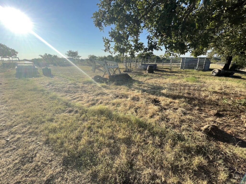 An outdoor area with old equipment and junk, indicating a cleanup job by JB'S Junk Removal in Justin, TX.