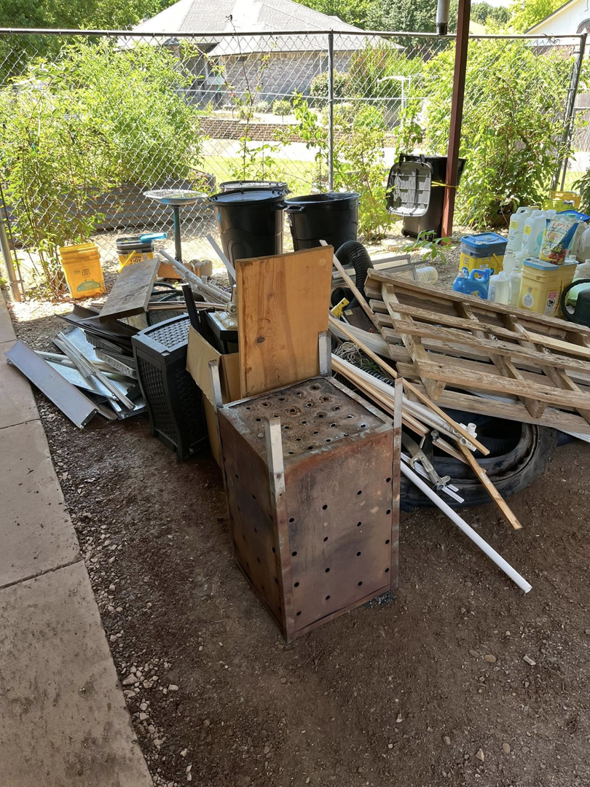 A large pile of outdoor junk, including wood pallets and metal debris, awaiting removal by Okc Junk Haul & Delivery in Oklahoma City, OK.