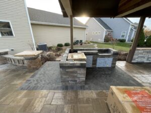 An outdoor kitchen and bar area under construction with pavers by Wildflower Landscapers LLC in Larsen, WI