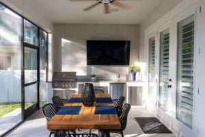 An inviting outdoor kitchen and dining area within a screened patio built by Landscape-Fusion in Tampa, FL