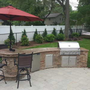An outdoor kitchen with granite countertops and a built-in grill installed by LJ Marble & Granite in Paterson, NJ.