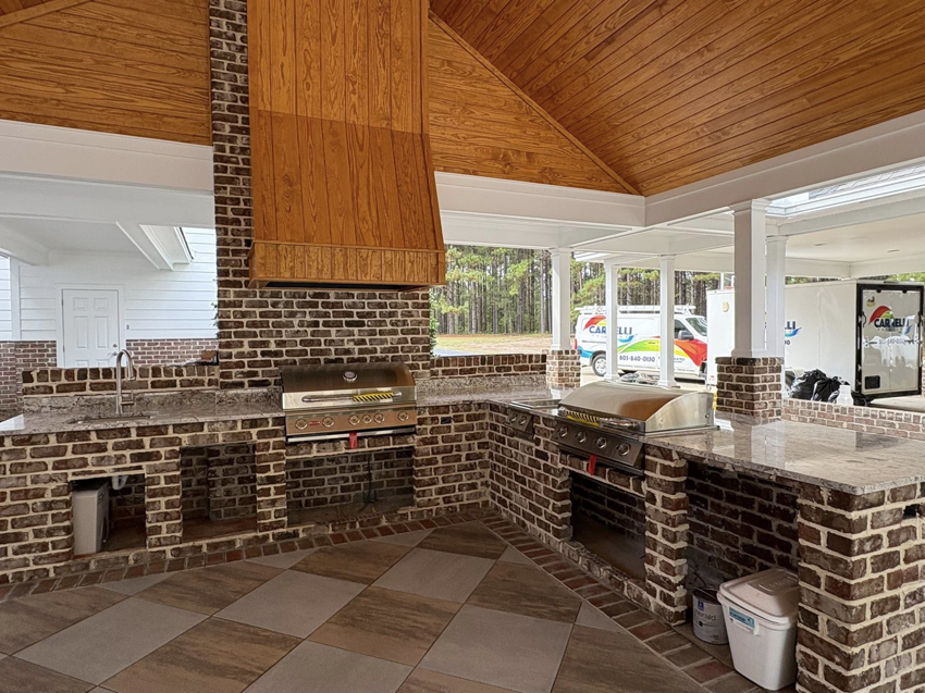 Detailed view of an outdoor kitchen with brickwork and built-in grills by Carnelli Painting in Sumter, SC.