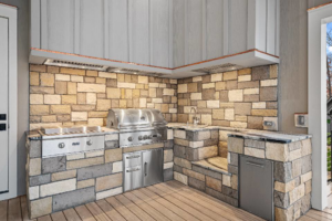 A beautifully installed outdoor kitchen with a built-in grill, sink, and refrigerator by CML Builders in Charlotte, NC.